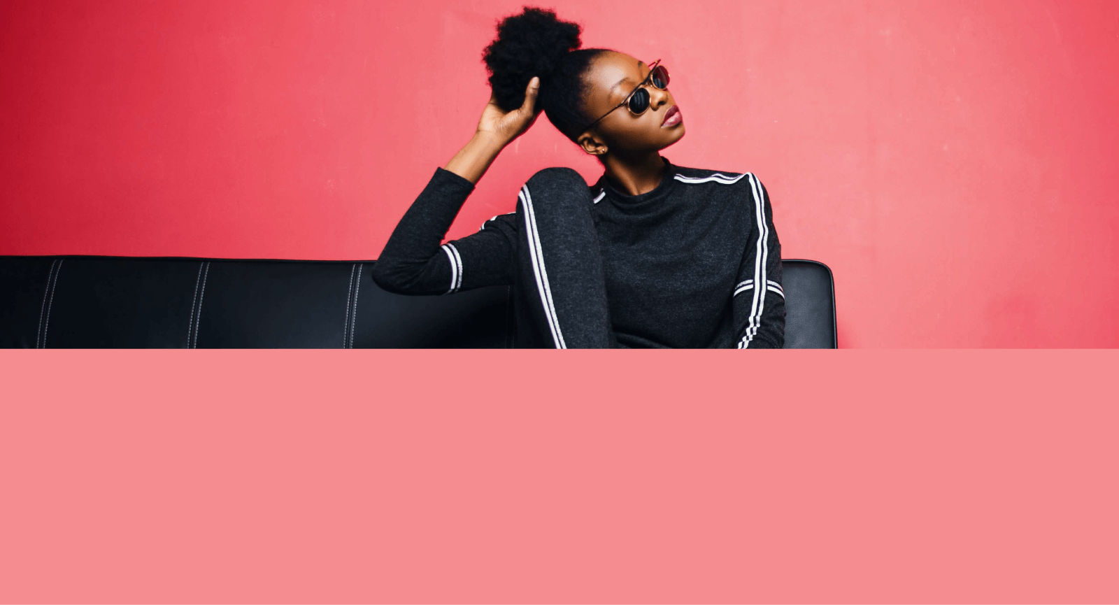 modelo feminina usando camisa preta em fundo rosa